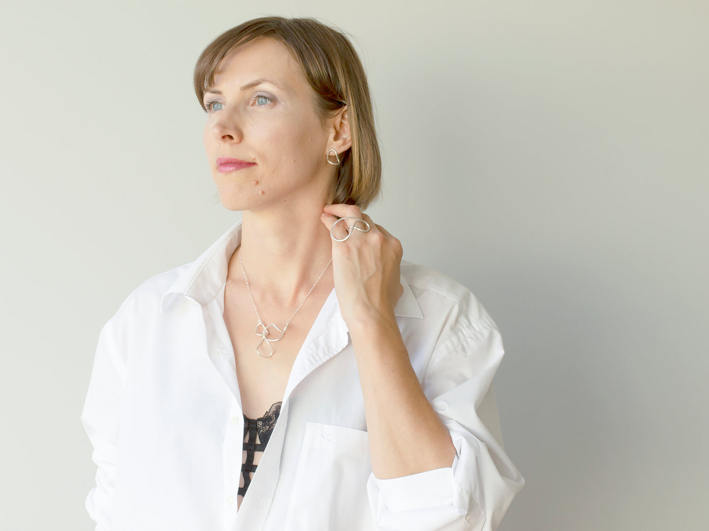 A woman wearing sculptural sterling silver jewelry