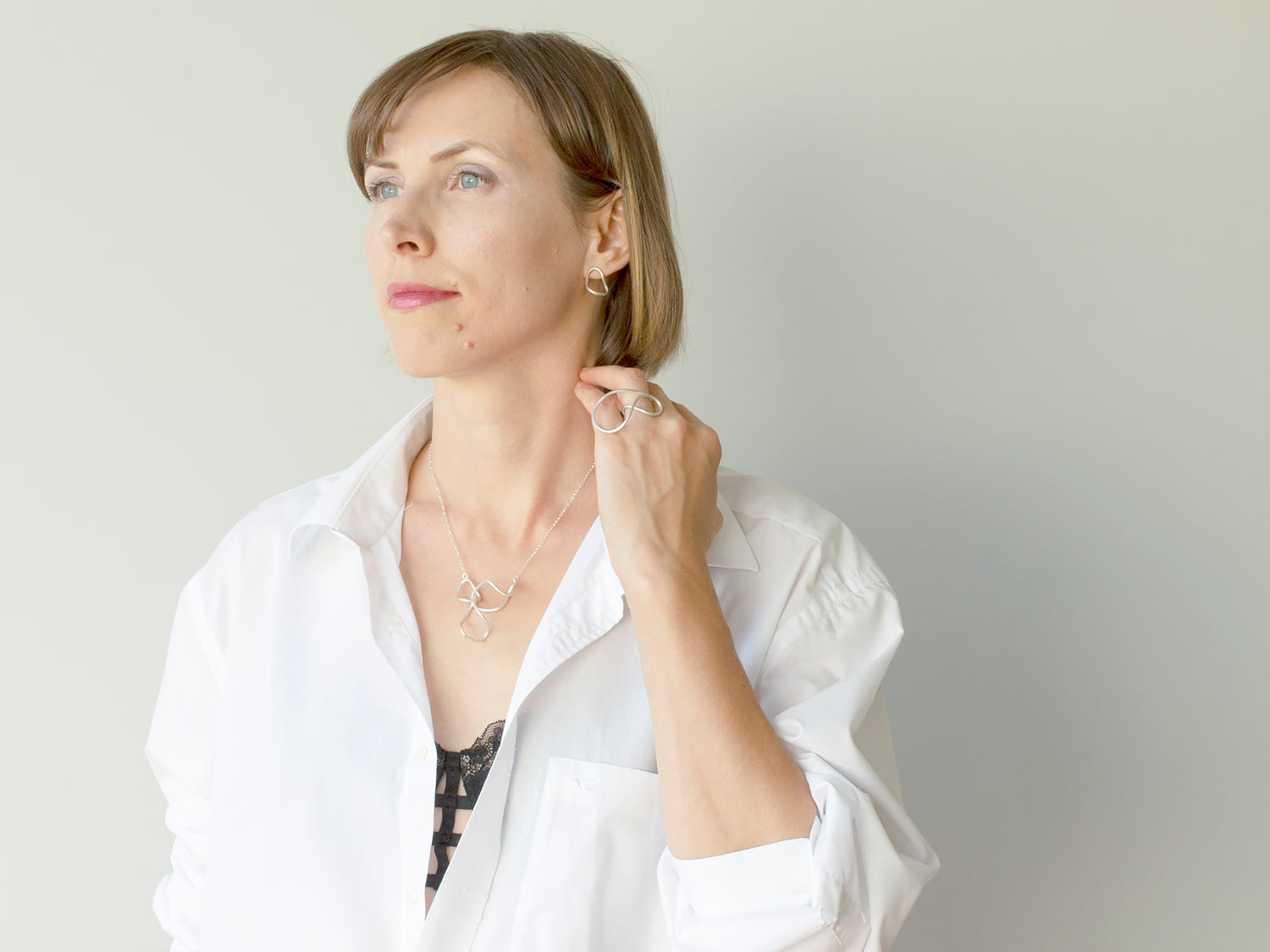 A woman wearing sculptural sterling silver jewelry
