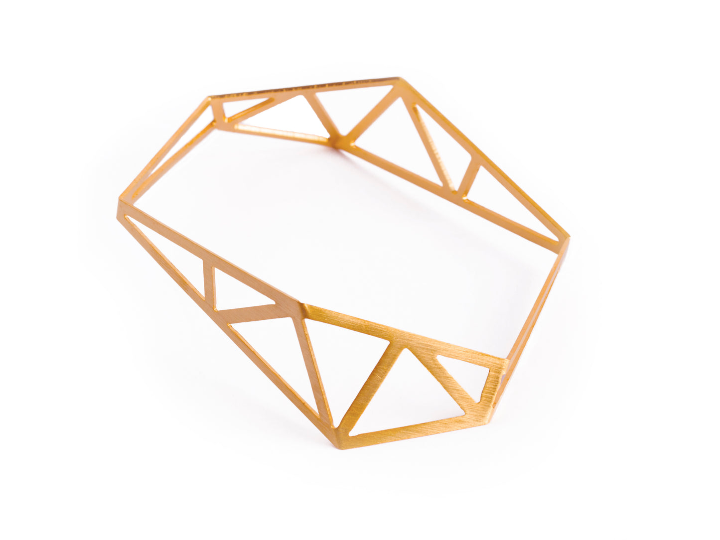 Architecture inspired geometric gold bangle made of folded and cut out metal sheet. Inspired by steel constructions, lightweight, three-dimensional