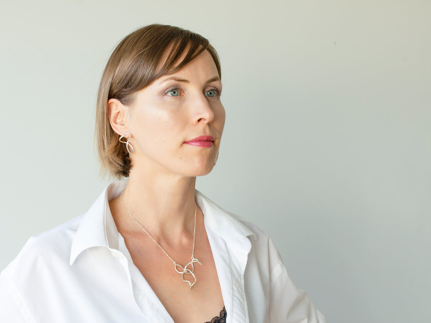 A woman in white shirt and organic shape sterling silver jewellery