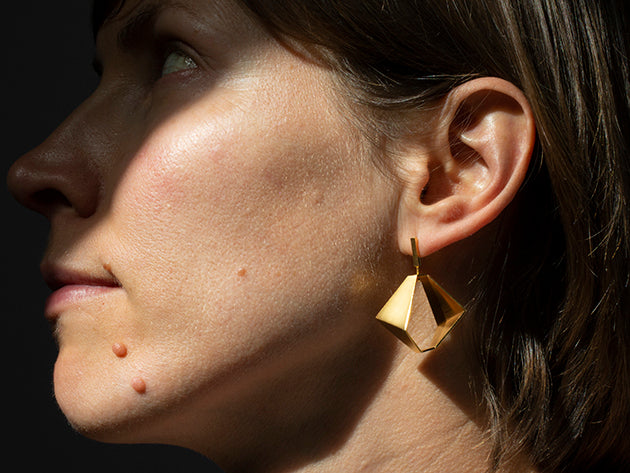 Woman with geometric gold earrings