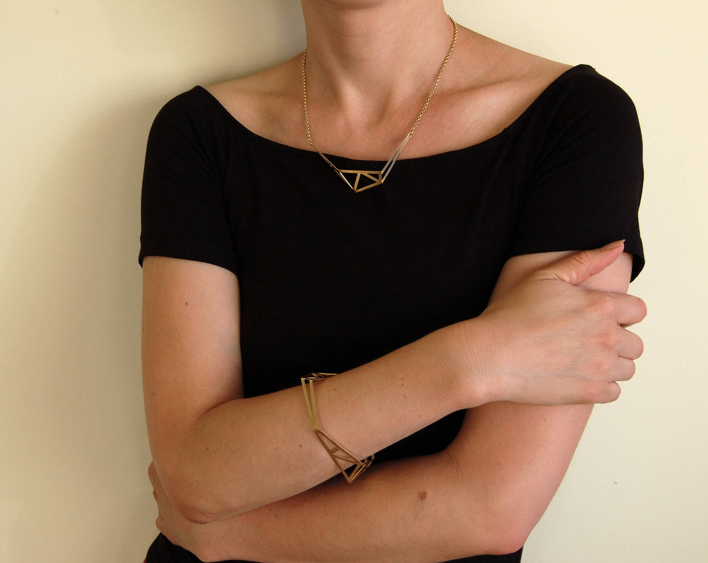 Architecture inspired geometric gold bangle made of folded and cut out metal sheet. Inspired by steel constructions, lightweight, three-dimensional