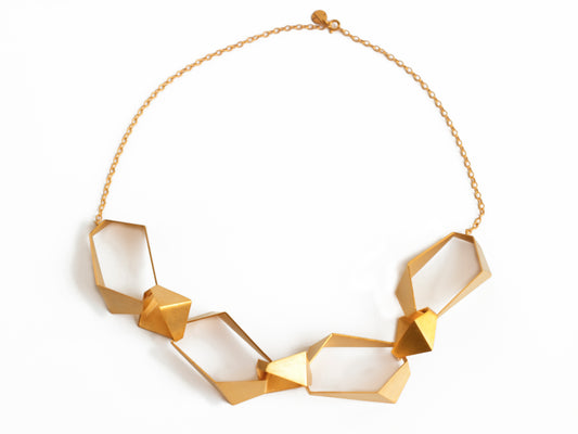 Geometric chunky link statement necklace made of 7 geometric links and gold chain