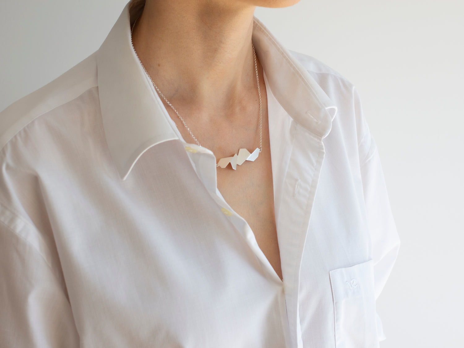 A white shirt styled with geometric sterling silver necklace